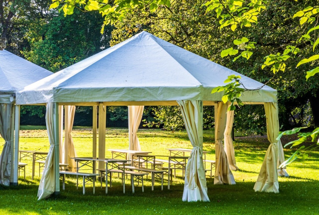 Pavillon Zelt mit Bierzeltgarnituren und offenen Seiten in Garten